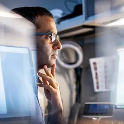 Photo of Yadav Sapkota, PhD, examining protein model data related to biomarkers that can predict cardiac issues in cancer survivors.