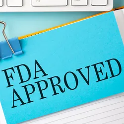 Photo of a piece of paper that reads "FDA Approved" on a clickboard.