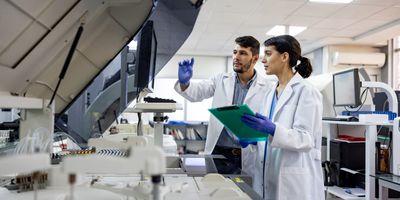 Photo of two laboratory scientists working at a flow cytometer in the clinical laboratory.