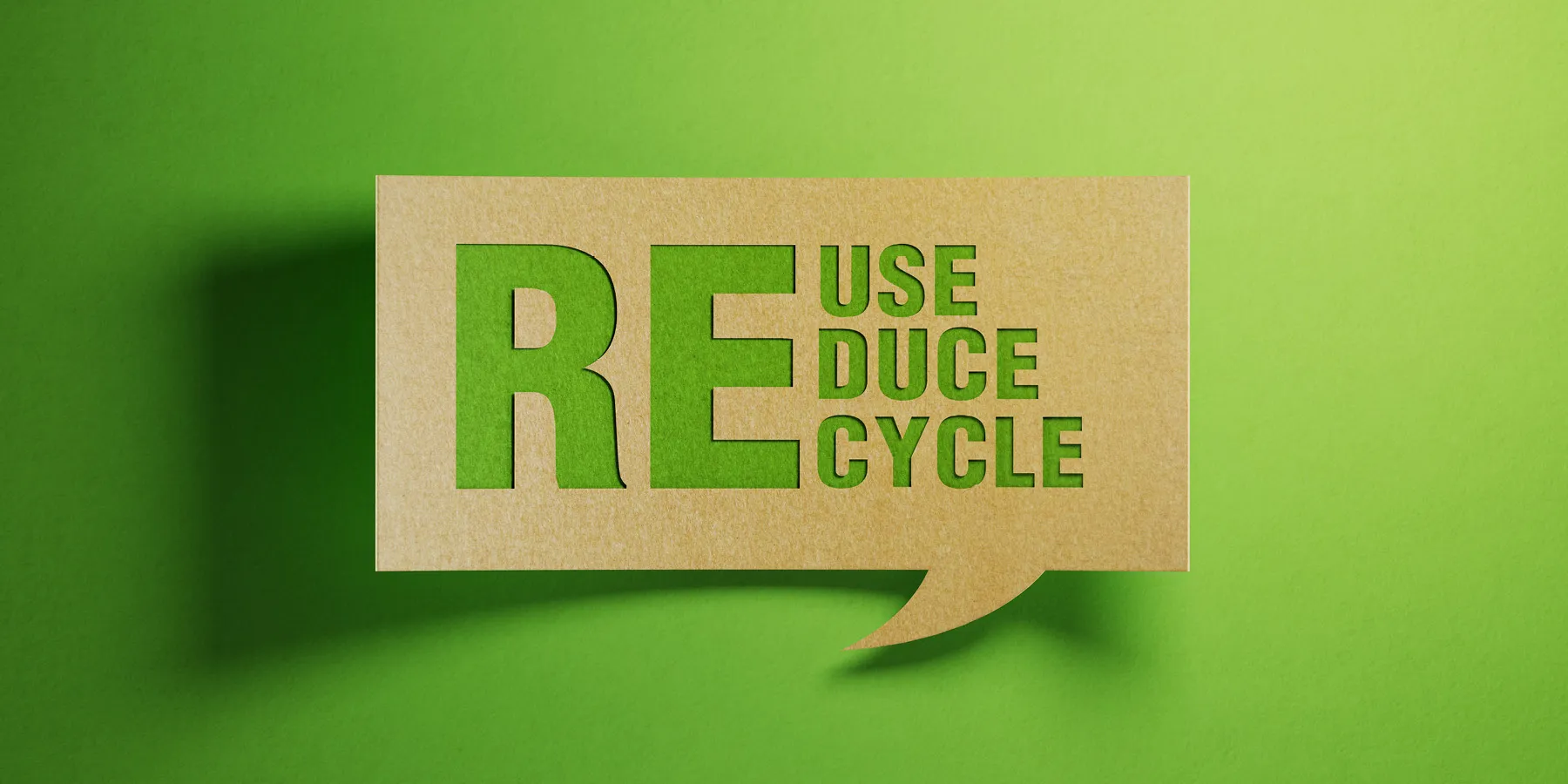 Photo of the words Reuse, Reduce, Recycle in green against a cardboard background representing sustainability practices.