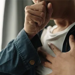 Photo of a person with a respiratory infection coughing into their closed fist.