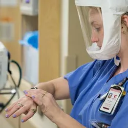 A healthcare provider cleans their hands. Hand hygiene is a crucial measure to prevent the invisible spread of C. difficile and other infections.