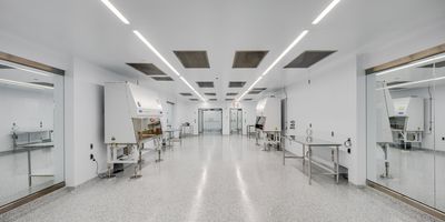 Photo of the inside of the Theragent project cleanroom where the floor, walls, and most equipment are white and the environment is sterile and bright.