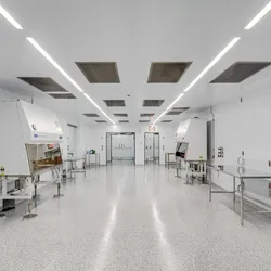 Photo of the inside of the Theragent project cleanroom where the floor, walls, and most equipment are white and the environment is sterile and bright.