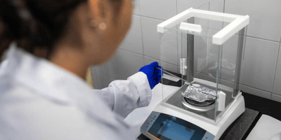 Scientist using an analytical balance