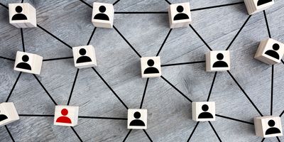 Photo showing several wood blocks with outline of human head and shoulders with one block in red, representing a positive sample of prostate cancer screening.