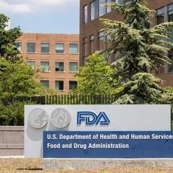 Photo of the main sign at the U.S. FDA Headquarters, White Oak Campus, showing buildings and trees in the background.