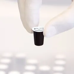 Gloved hand holding dry reagent cup