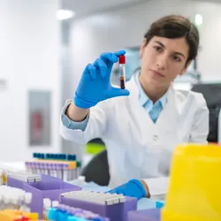 Scientist examining a blood sample in a laboratory focused on sample management processes