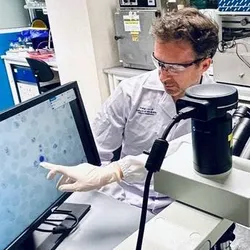 Assistant professor Benoit Malleret (left) and Dr. Hang Jing Wen (right) examining blood smears from Plasmodium coatneyi in the laboratory.