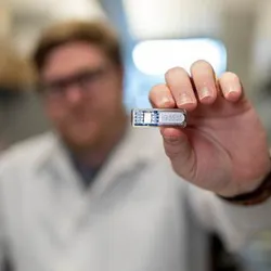 Rice University PhD student Chris Wright holds the implant, which uses cells to manufacture pharmaceutical drugs beneath the skin.