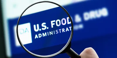 Magnifying glass over U.S. Food and Drug Administration website logo on a computer screen.