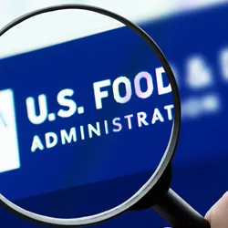 Magnifying glass over U.S. Food and Drug Administration website logo on a computer screen.