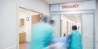 Medical personnel in a hospital rushing an overdose patient on a gurney into the emergency room.