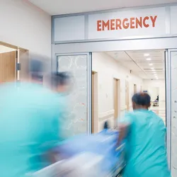 Medical personnel in a hospital rushing an overdose patient on a gurney into the emergency room.