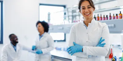 Smiling laboratory technician demonstrating rapid molecular testing in a clinical laboratory.