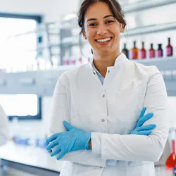 Smiling laboratory technician demonstrating rapid molecular testing in a clinical laboratory.