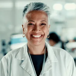 Clinical lab director smiling in a laboratory setting preparing to evaluate a new platform.