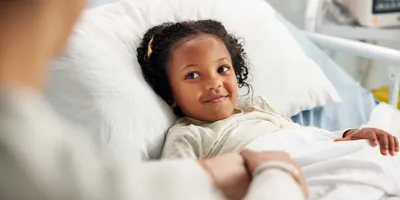 Young girl in a hospital bed, reflecting the care for early-stage type 1 diabetes.