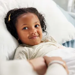 Young girl in a hospital bed, reflecting the care for early-stage type 1 diabetes.