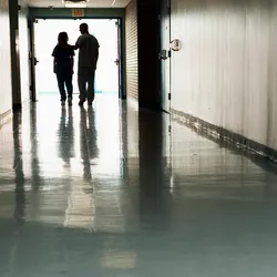 Health professionals walking in a hospital corridor responding to a possible drug overdose.